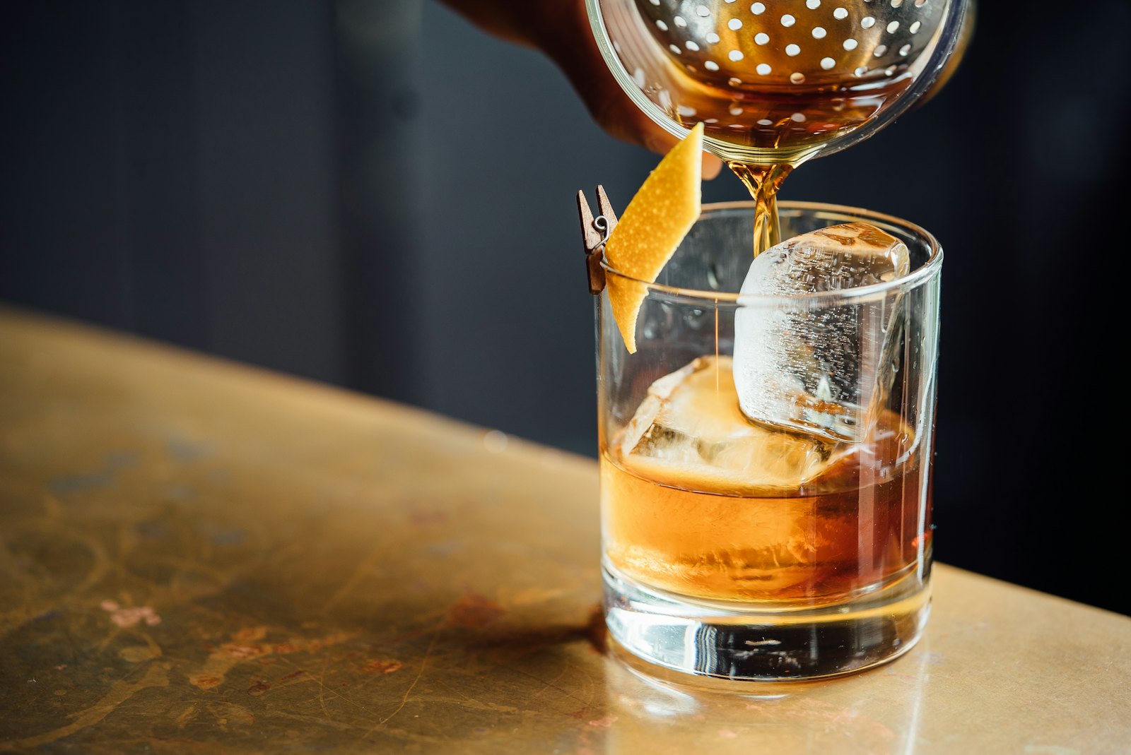 An old fashioned being poured at the bar